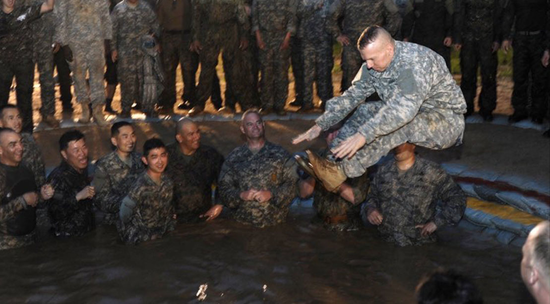 SEAC John Troxell pulando em uma piscina com recrutas da marinha