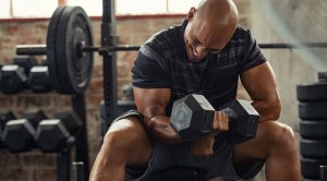Bald fitness enthusiast working out with a single dumbbell increasing his training intensity