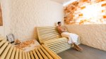 Man sitting in a dry sauna surrounded by salt blocks