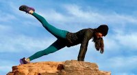 Samantha Harris performing a yoga pose on top of a rock