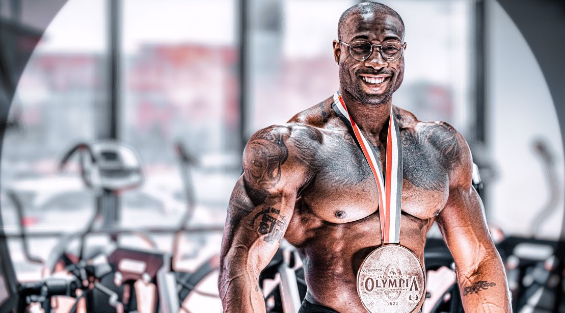 Erin Banks wearing his olympia medal in the gym