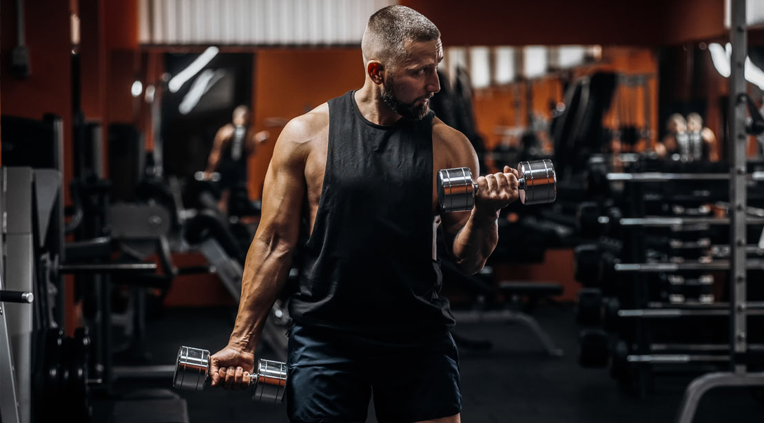 Man in his 40's working out with light weight dumbbells