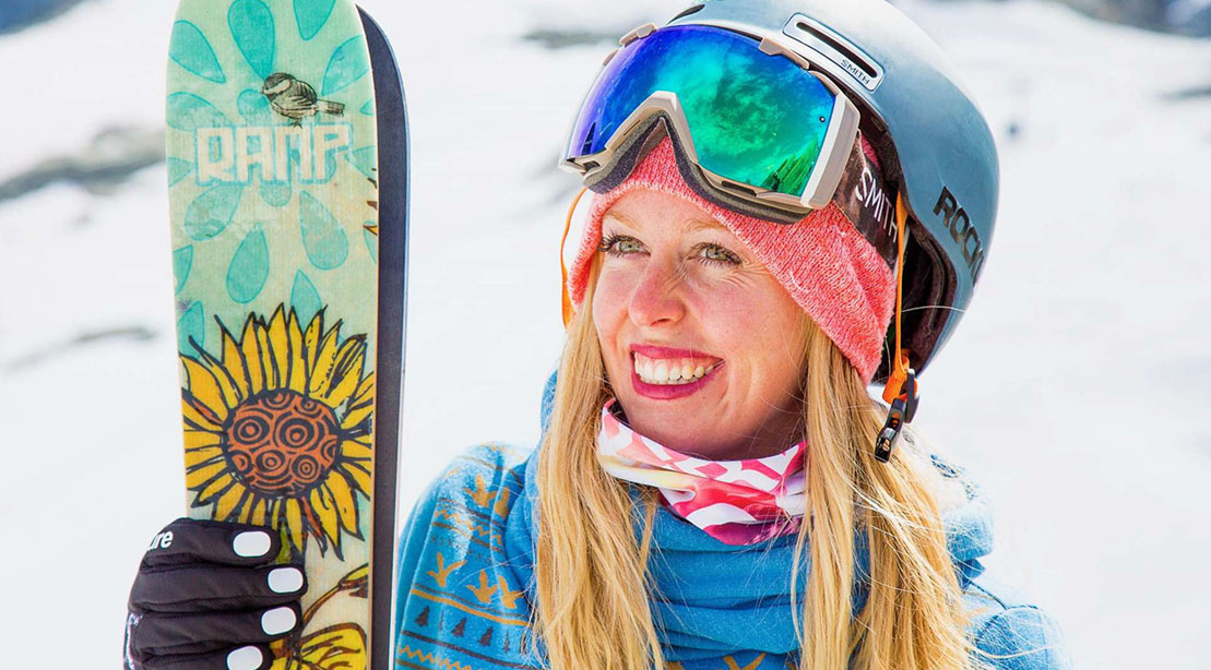 Skiier Jamie Crane-Mauzy holding her skiis and wearing protective winter gear