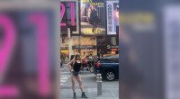 Kirra Collins in Times Square pointing at her billboard