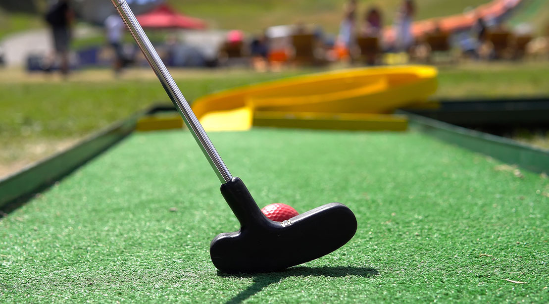 Putter set up for putting on a mini golf course