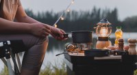 Camper using camping gear to heat up water on a propane burner