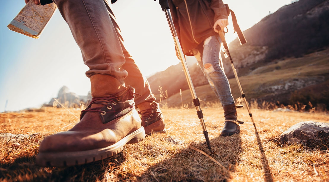 Couple legs hiking with hiking boots and hiking poles