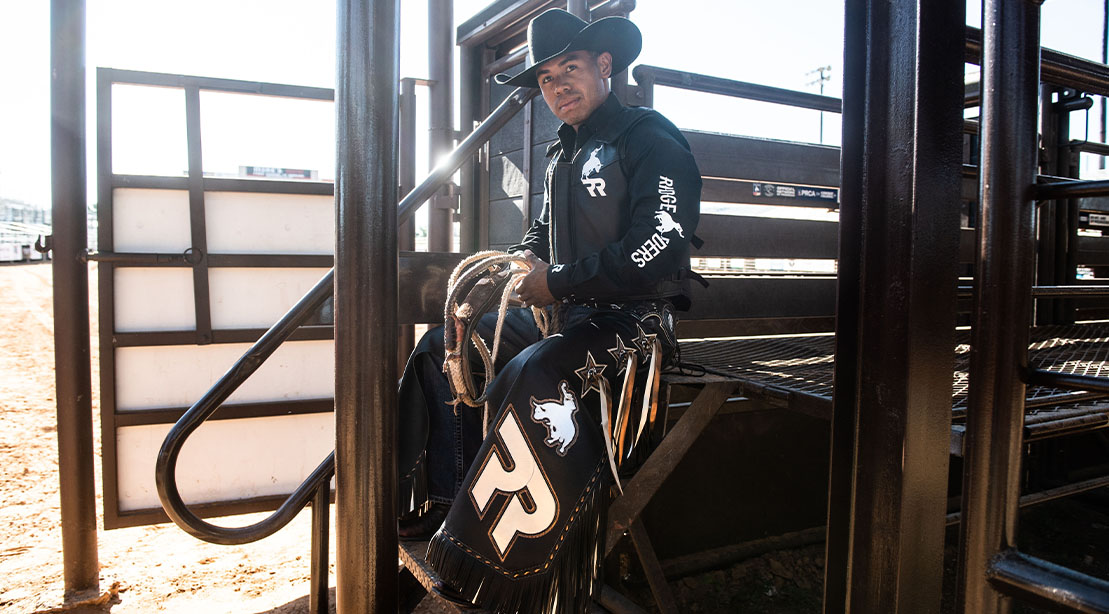 Bull Rider Keyshawn Whitehorse in the stables wearing his cowboy gear