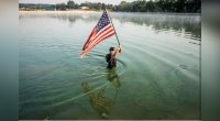 Billy Richards carries flag in water