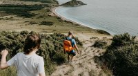 Two hikers approaching a downhill hike on the coastline