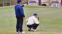 Old men playing golf and setting up their putting line