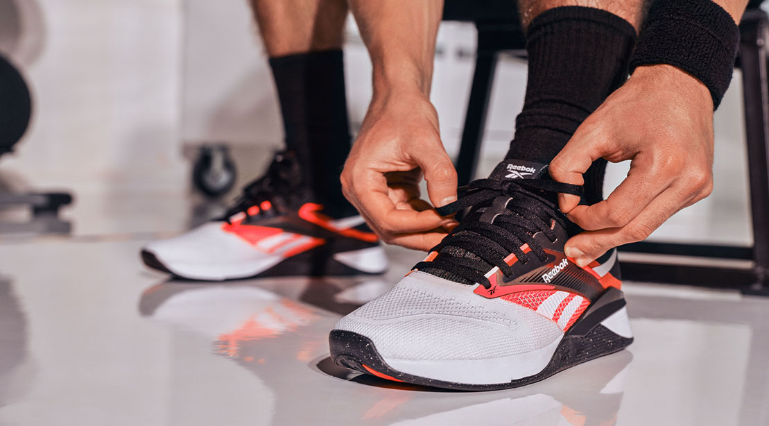 Fit man tying his Reebok NANO X4